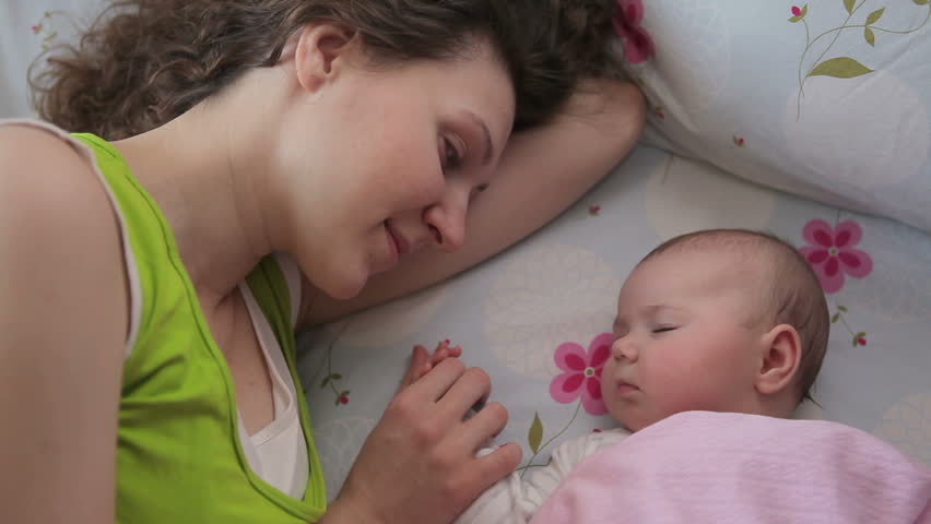 Mom kisses a sleeping baby