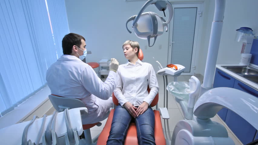 Crane shot of dentist examining oral cavity of a patient with toothache