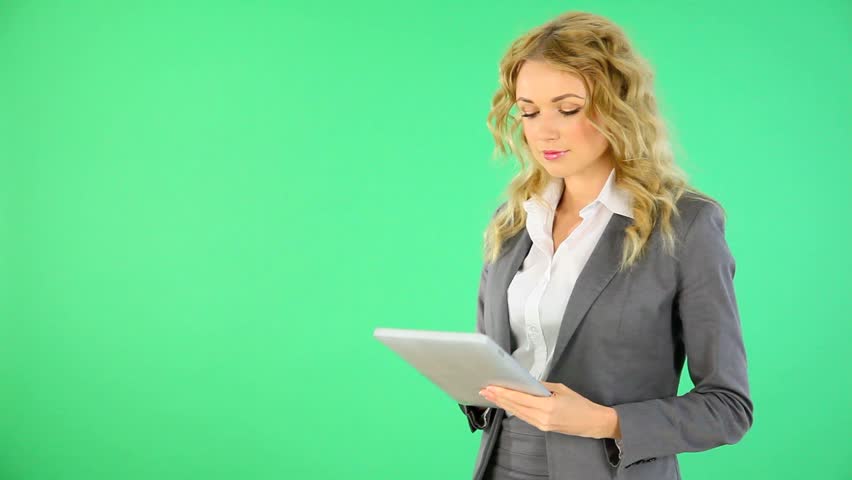Businesswoman standing on green background with digital tablet