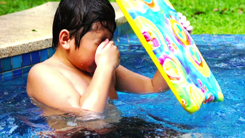 Asian boy playing in the swimming pool.