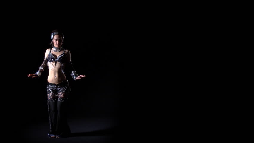 Young girl in modern alien costume dancing tribal on black background. Copy space. Studio shot. Professional lighting.