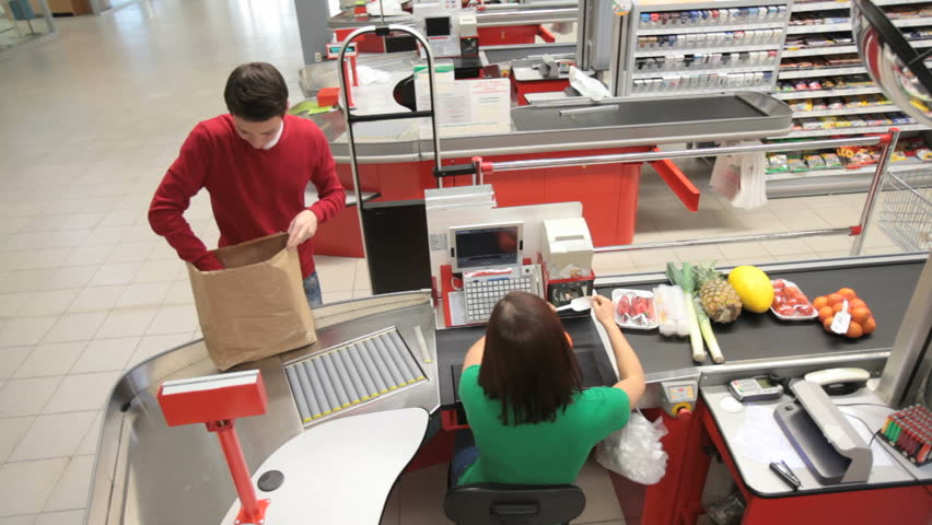 Young man paying for goods at the check counter