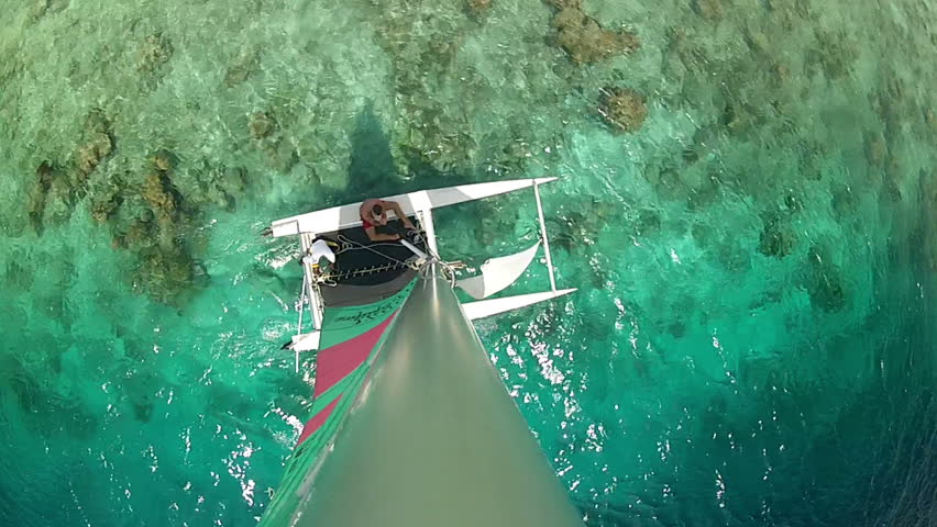 catamaran sailing in lagoon near coral reef, top view