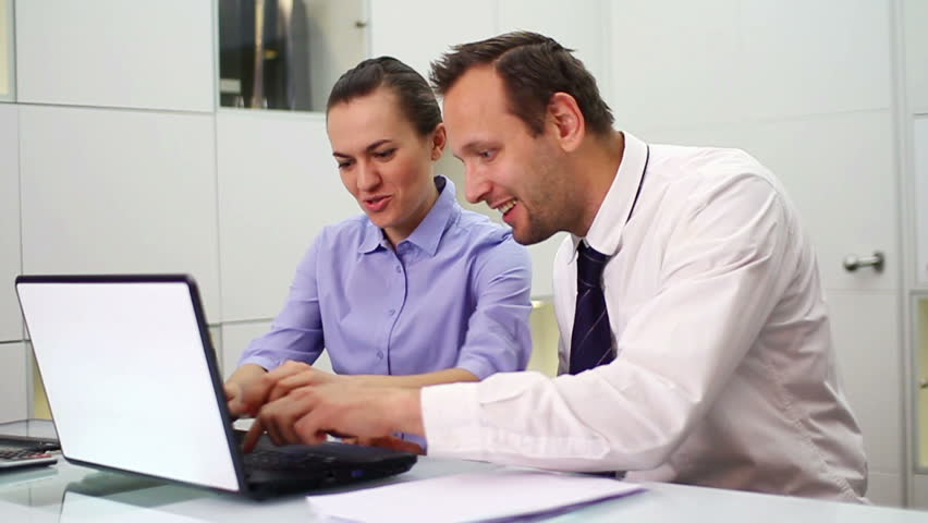 Successful, excited business people with laptop in office, slow motion