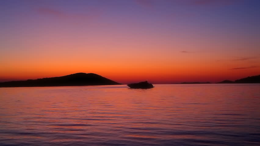 Sunset with yacht, island and horizon. Shot on island Dugi otok near Zadar, Croatia