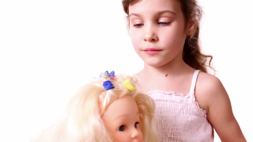 Little girl use elastic band to braid dolls hair, isolated on white background