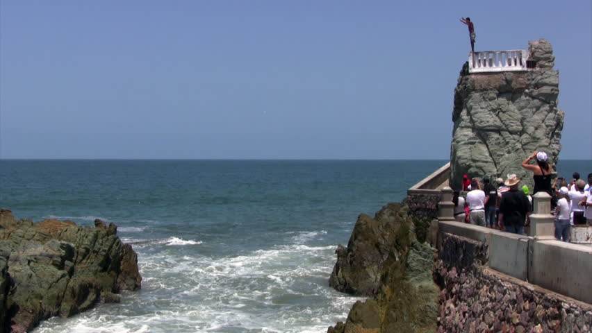 Cliff diver with spectators