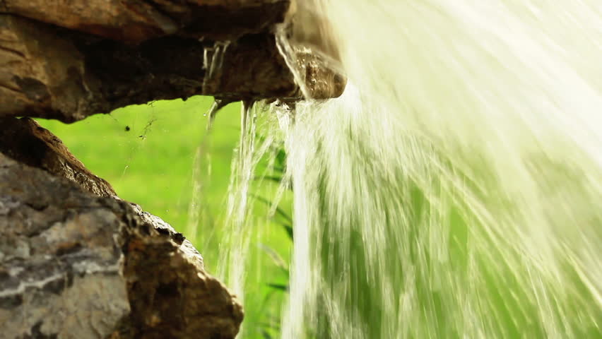 Water bursting out of stone spring in nature