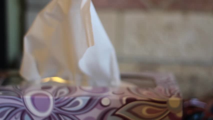 A man grabs some tissue from a box