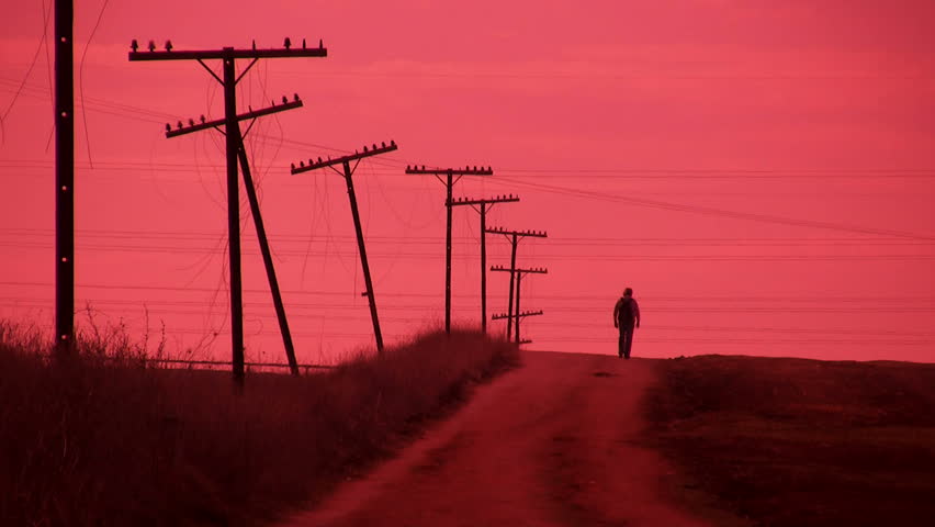 Man walking on a country road - red tint