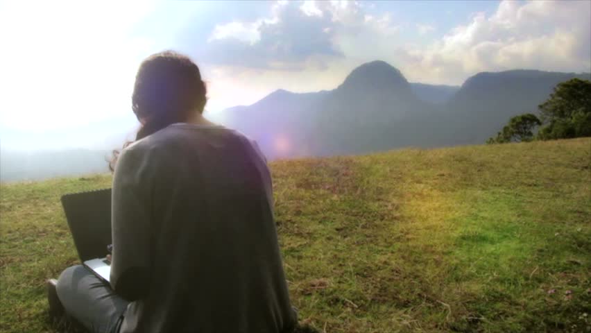 Girl work on lap high mountain, tracking shot with flare