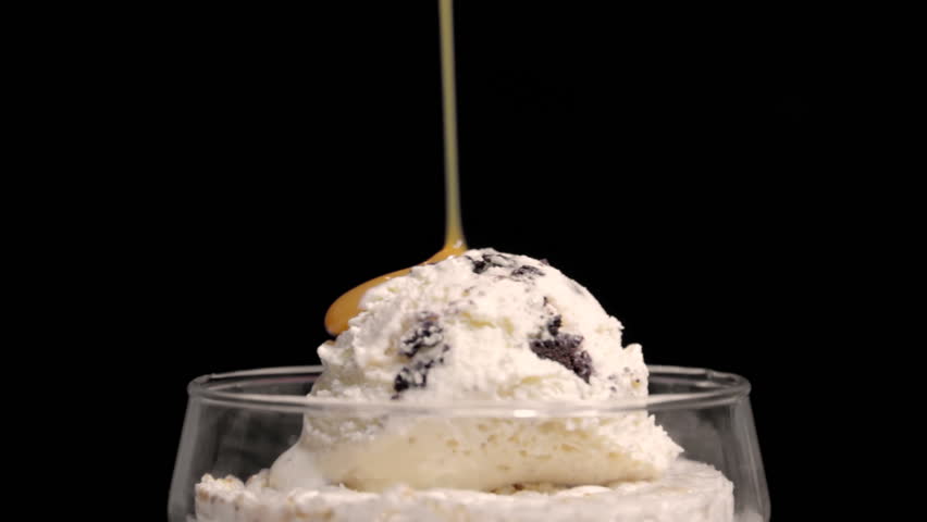 Caramel Sundae with Cherry (HD). Caramel Sundae ice cream being drenched in caramel and chocolate sprinkles with cherry placed on top.