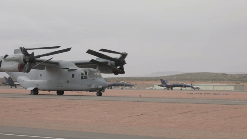 Navy Blue Angel air demonstration F18 Hornet fighter jets taxi past V22 Osprey vertical takeoff and landing VTOL USAF aircraft in Utah. Used in Iraq and Afghanistan.