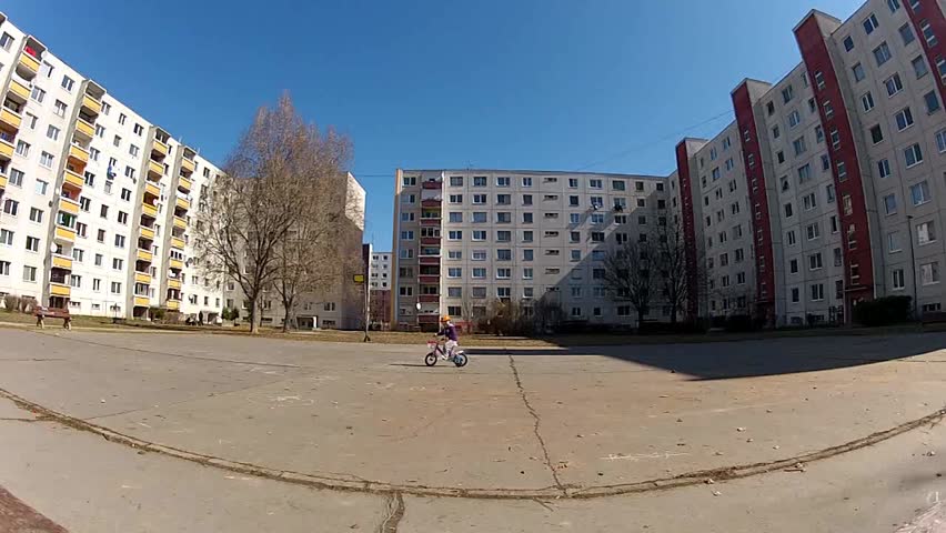 Baby girl in helmet learning to ride on bike 