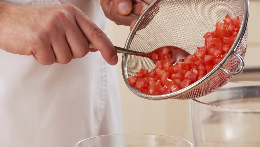 Diced tomatoes being tipped into a bowl