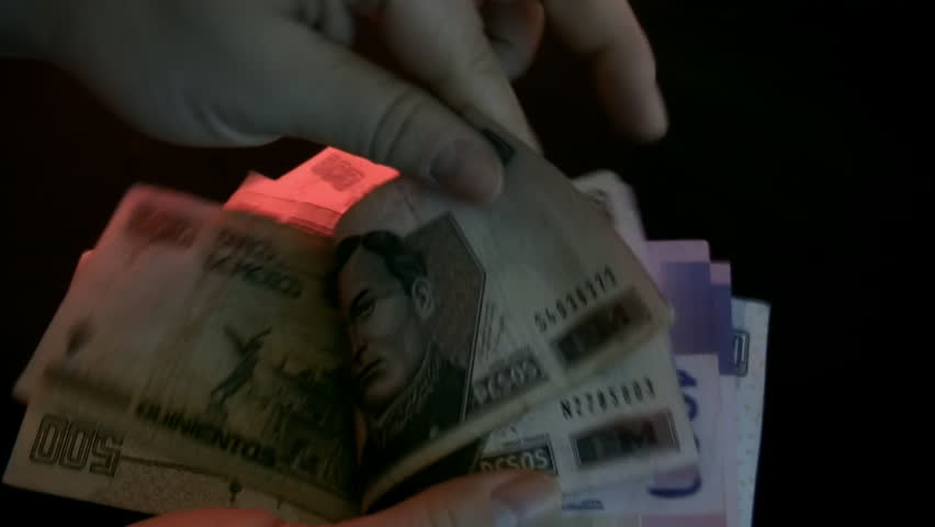 Counting Mexican Bills (HD). Mexican money counted by female hands with ambient audio. Shot with studio lights and colored gels for visual ambiance.