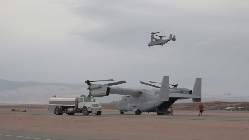 ST GEORGE, UTAH - MARCH 17: Aircraft V-22 Osprey VTOL hover mode doing vertical takeoff and landing over flight line and fuel truck on March 17, 2012 in St. George, Utah. USAF, Marines, Navy and NATO allies for transportation.