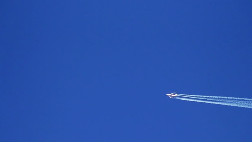 Airplane vapour trails across clear blue sky (slow motion)