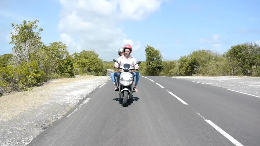 Couple enjoying scooter ride on country road