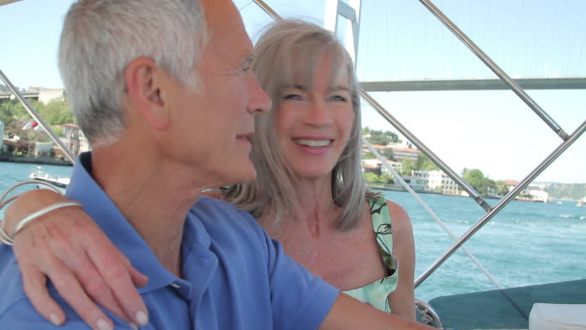 Senior male captain and female on nautical vessel