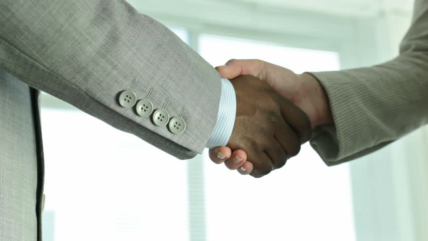 Two positive businesspeople shaking hands indicating a concluded deal