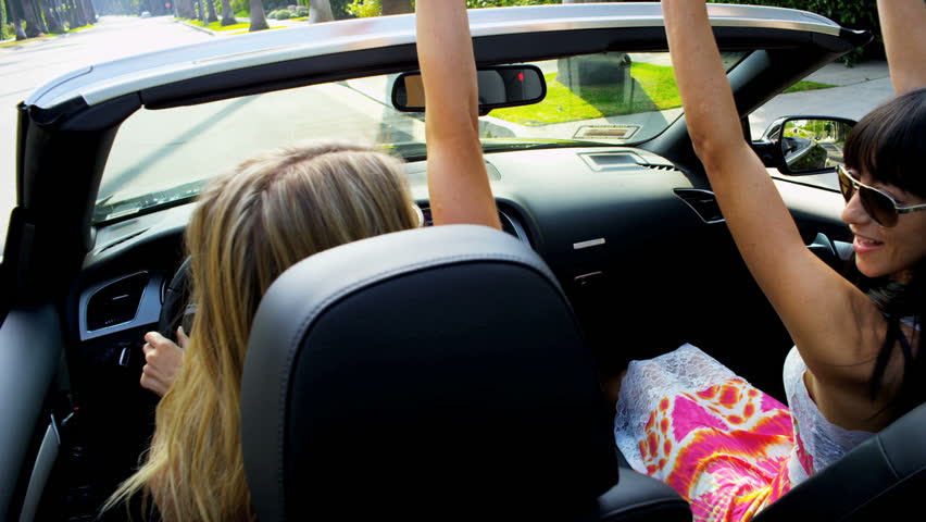 Close up of crazy girls in an open top car
