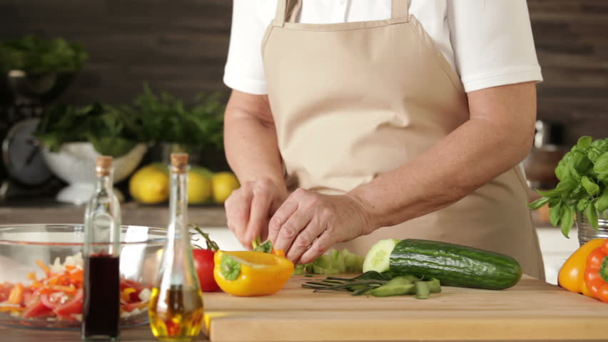 cutting cucumber and paprika for fresh mixed salad
