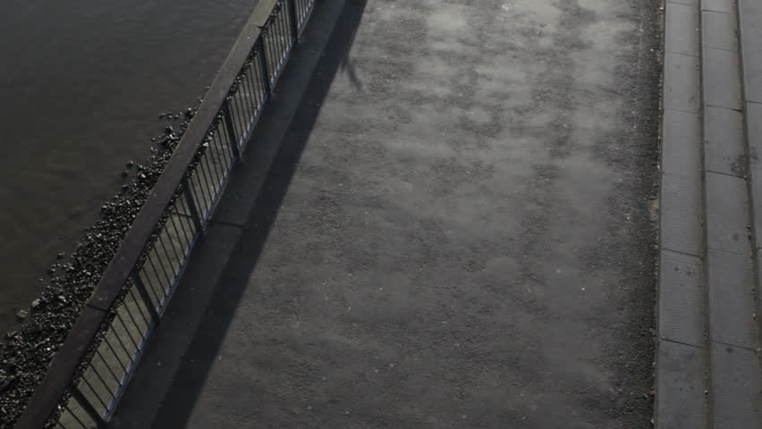 Runner on embankment under millennium bridge, London, UK