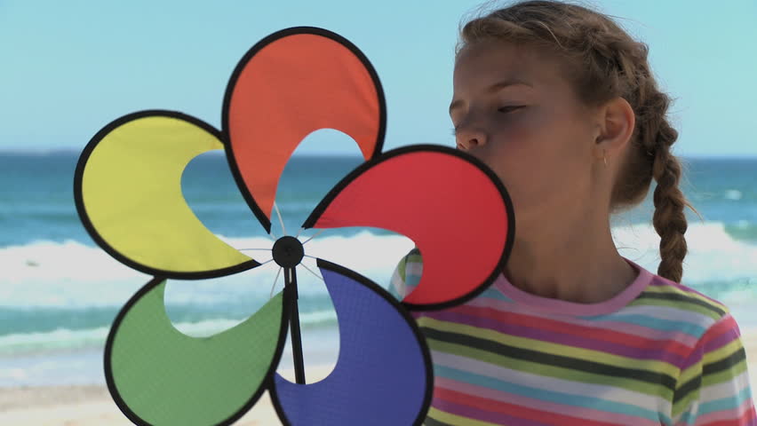 MEDIUM CLOSE UP OF A GIRL SPINNING A PIN WHEEL