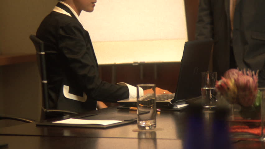 MEDIUM SHOT PAN OF A BUSINESSMAN GIVING A PRESENTATION