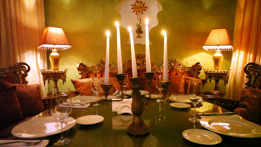 Five candles burn in table center in restaurant lounge