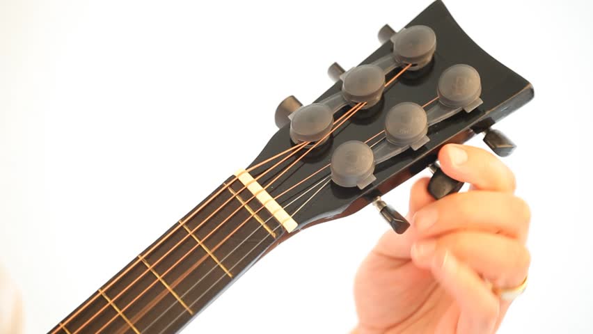 Person tuning a guitar