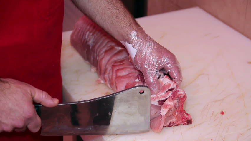 Butcher at work.
Butcher man hand cutting raw meat with meat chopper. HD1080p.