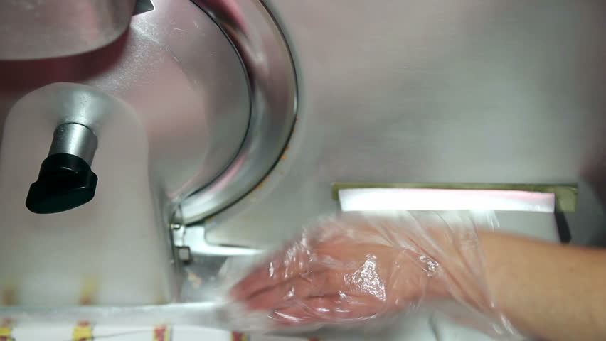 A woman cutting salami with a machine. HD1080p.