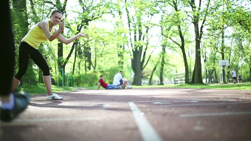 Two young women running on the track, dolly shot, slow motion 

