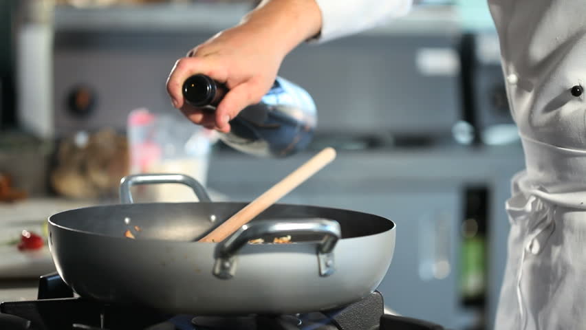 hand that fades with cooking wine in kitchen restaurant