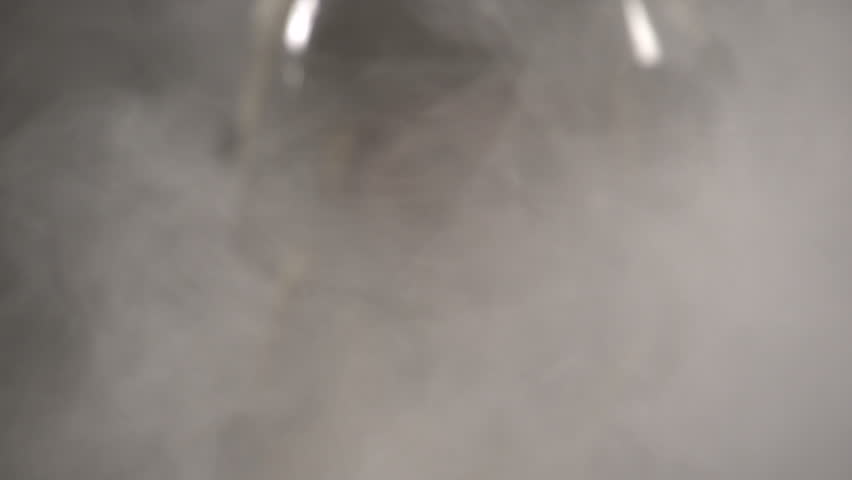 Firefighter walking towards camera through smoke, slow motion