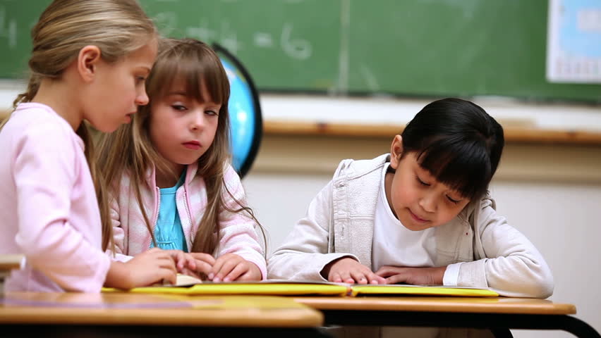 Pupils reading a book in a classroom