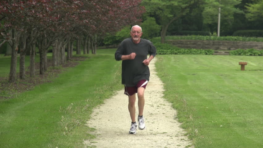 Older man running towards camera in slow motion