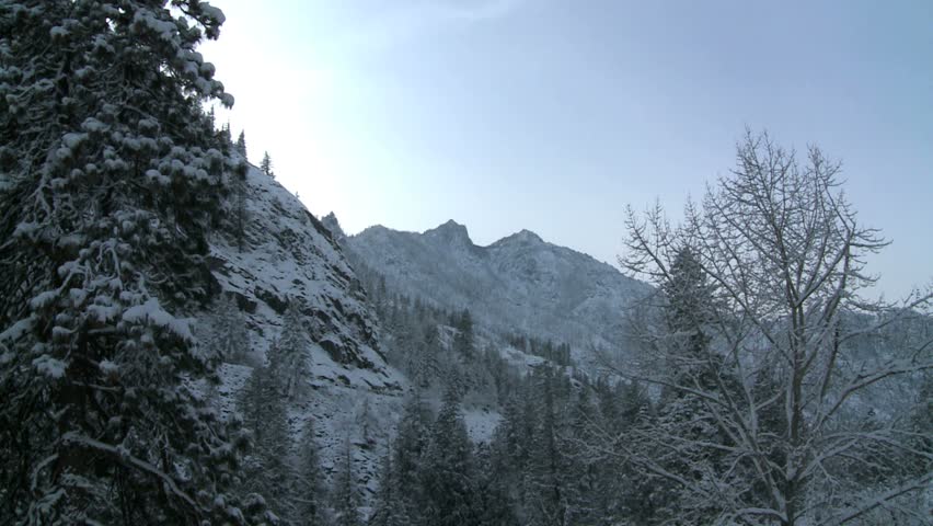 back lit mountains after sun is gone, tilt down to reveal icy snow covered stream, Leavenworth, Washington