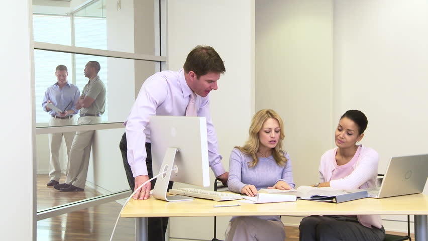 Group of coworkers at desk in busy office