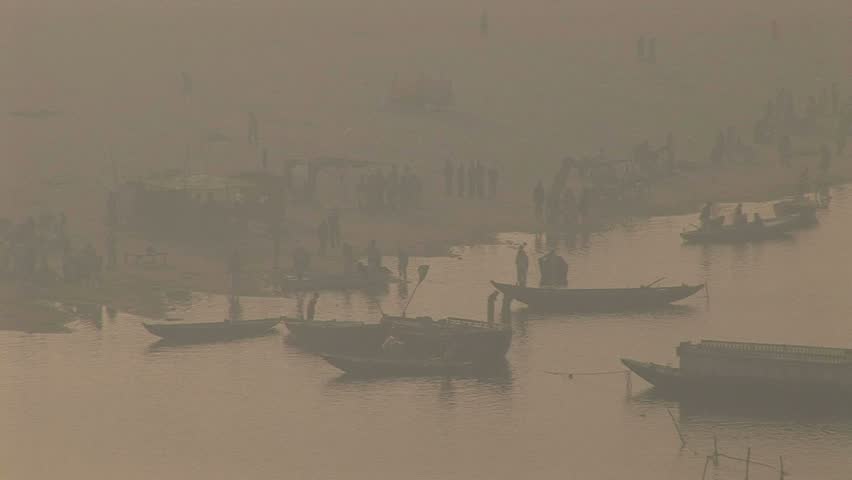 far bank Ganges river with pilgriMS bathing and boats arriving, Veranasi, India
