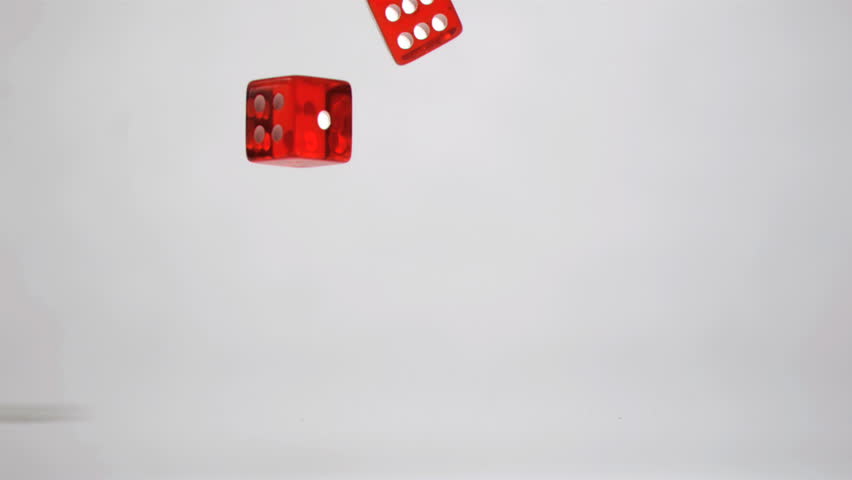 Two red dices in super slow motion turning against a grey background