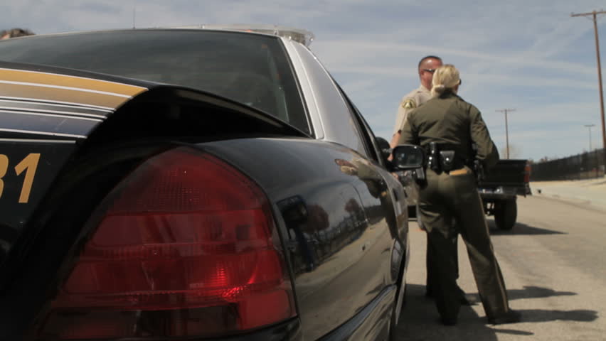 California - Circa 2009: Police officers on a California highway in 2009. CHP talking with county sheriff's officer in California.