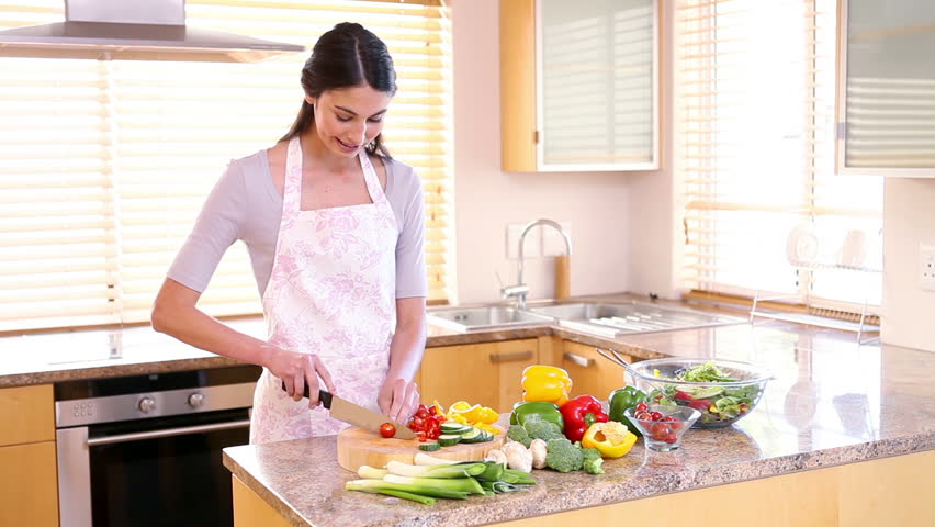 Young woman preparing a salad in her kitchen
