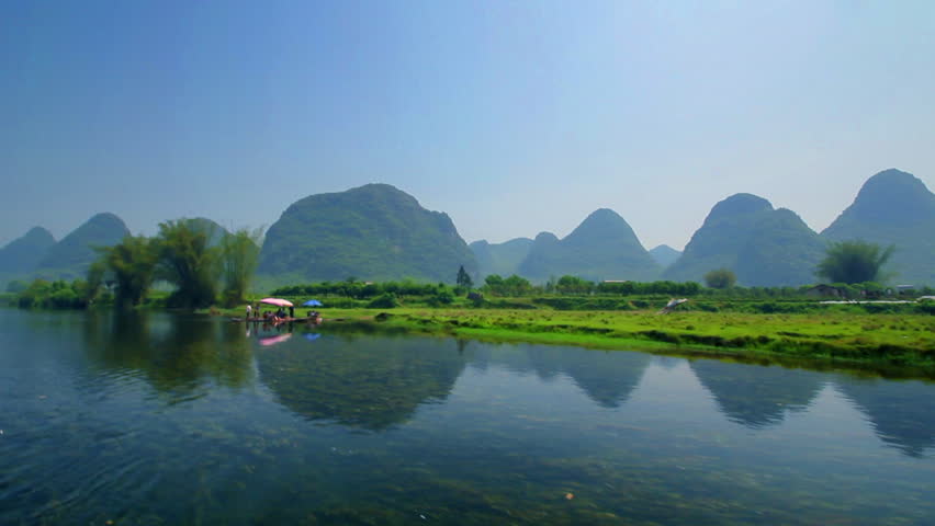 Bamboo raft flowing through the idyllic rural landscape of Yangshuo