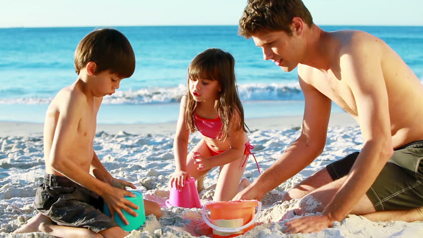 Smiling family building sand castles on the beach
