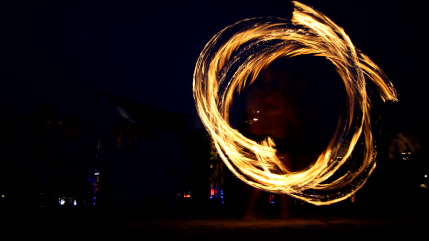 man at festival playing with fire sticks
