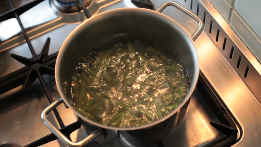 green beans boiling in hot water on a gas furnace