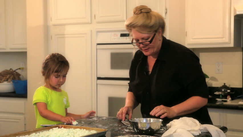 Grandmother and granddaughter making cookies together